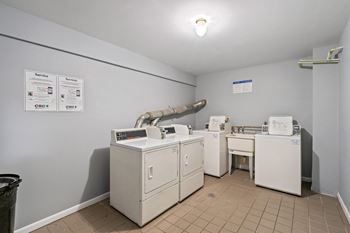 a laundry room with washers and dryers and a sink